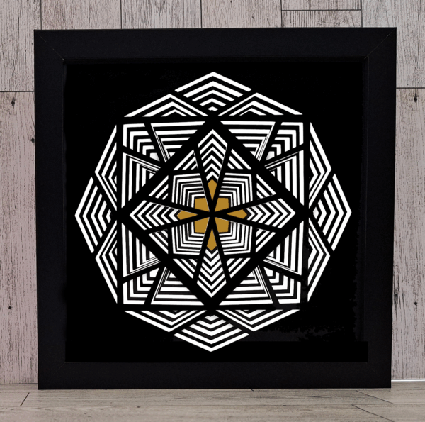 Layered black and white paper in a geometric design in black frame