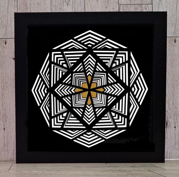 Black, white, and gold paper art in black frame