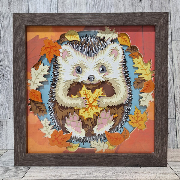 Happy Hedgehog holding leaves layered paper in brown frame