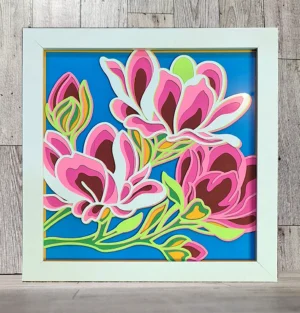 Magnolia flower made of layered paper in a white frame.